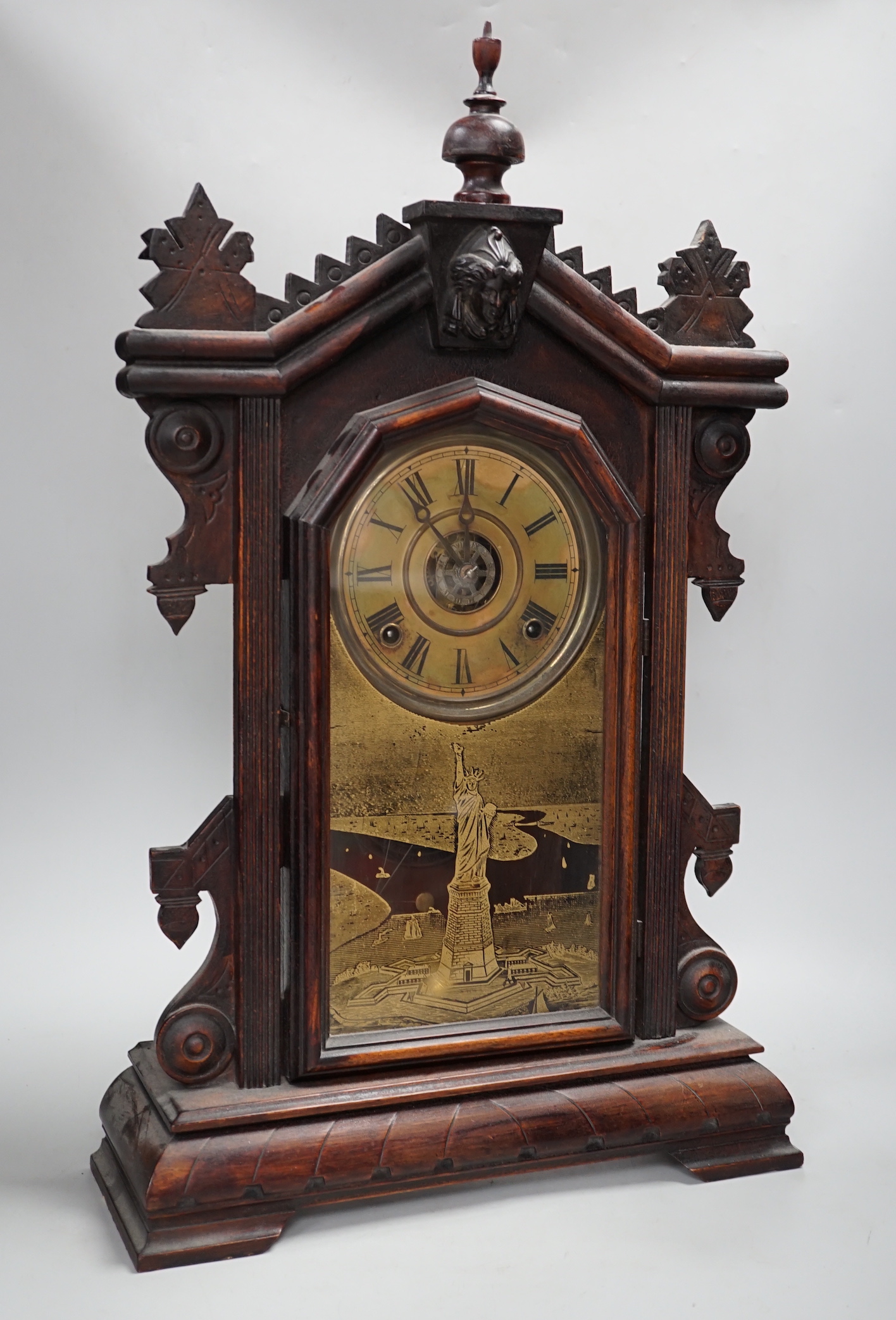 A 19th century American shelf clock, 60cm high, the glass decorated with the figure of the Statue of Liberty, 60cm high